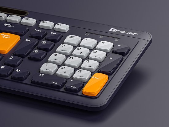 Detailopname van de rechterkant van een zwart toetsenbord. Oranje enter-toets en enkele witte numpad-toetsen.