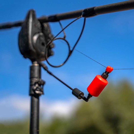 Un swinger de canne à pêche rouge avec un bras et une tige noirs, fixé à un piquet de canne à pêche avec un support noir.