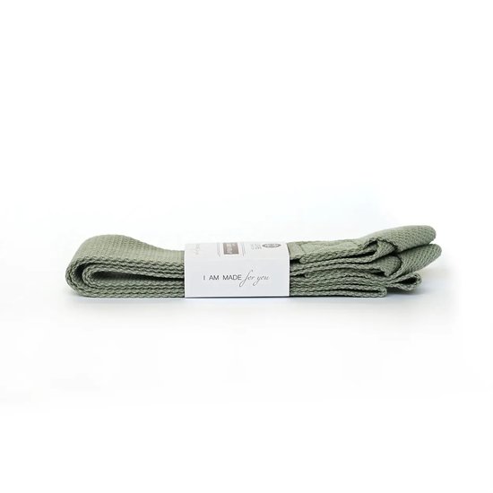 Sangle de transport vert clair pour tapis de yoga enroulée, avec une étiquette "I AM MADE for you".