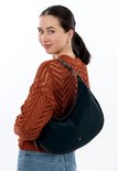 Model draagt een donkerblauwe buideltas met dierenprint accenten over haar schouder, samen met een oranje gebreide trui.