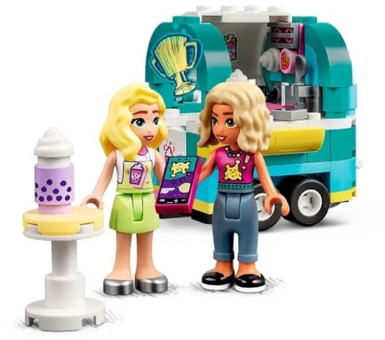 Twee LEGO Friends-poppen staan bij een mintgroene en gele mobiele bubbelthee stand met een paarse bubbelthee-automaat.