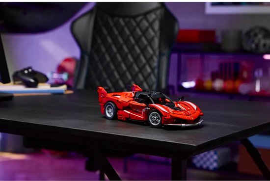Rode LEGO Technic Ferrari FXX K raceauto op een zwarte tafel.