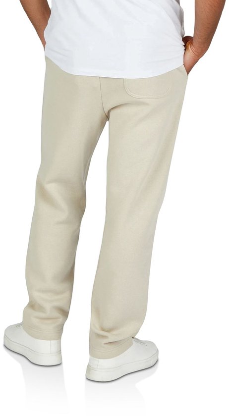 Man, van achteren gezien, draagt een beige joggingbroek met een witte T-shirt en witte sneakers.