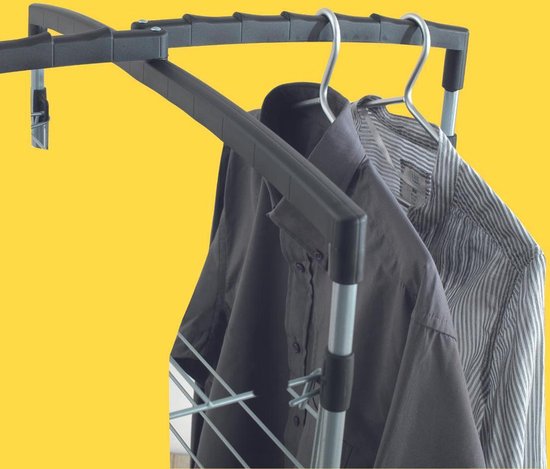 Detailopname van een zilverkleurige droogtoren met zwarte bovenrails, met gestreepte en donkerblauwe hemden eraan.