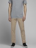 Model in een grijs T-shirt en beige chino. De voorkant van de broek is zichtbaar.