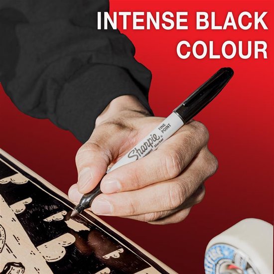 Een hand met een zwarte Sharpie marker die op een skateboard tekent. Tekst "INTENSE BLACK COLOUR" bovenaan.