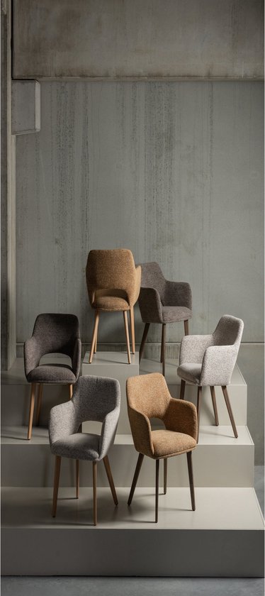 Groep van zeven eetkamerstoelen in verschillende kleuren, waaronder taupe, op een trap.