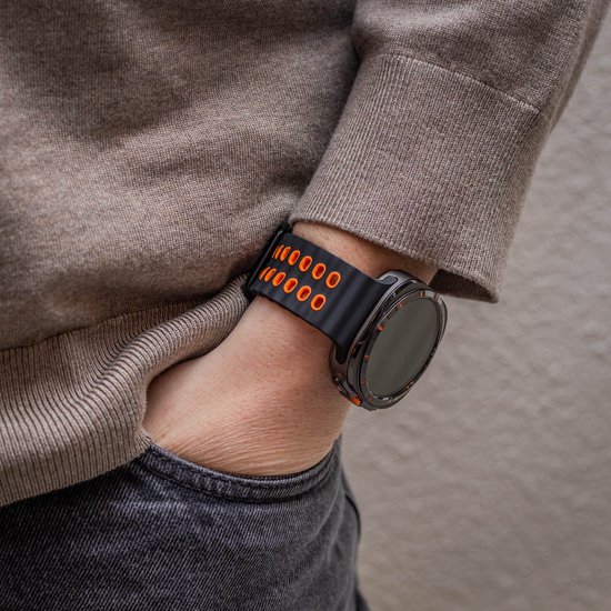 Polshorloge met zwart en oranje siliconen bandje met ronde perforaties.
