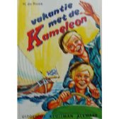 Vakantie met de Kameleon. Twee lachende jongens op een boot, met zeilboot op de achtergrond.