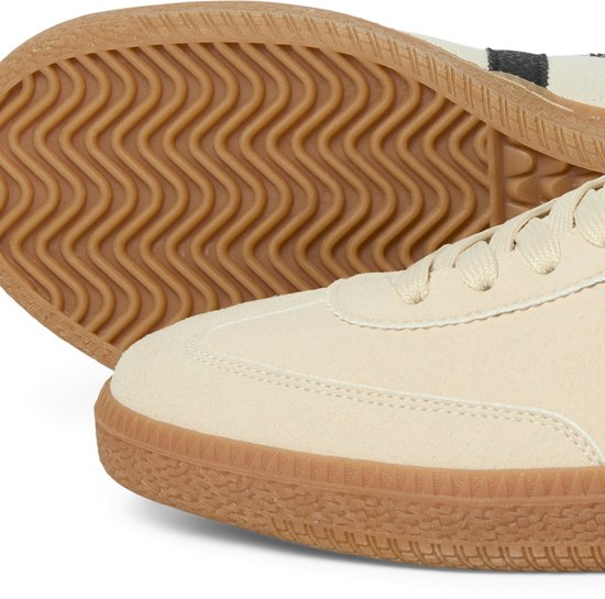 Detail van de voorkant en zool van beige suède sneakers.