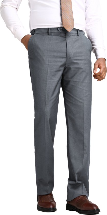 Homme en pantalon gris avec une chemise blanche et une cravate à rayures, mains dans les poches.