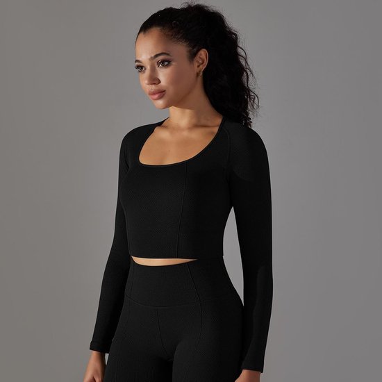 Zwarte, nauwsluitende crop top met lange mouwen en vierkante halslijn, gedragen door een vrouw.