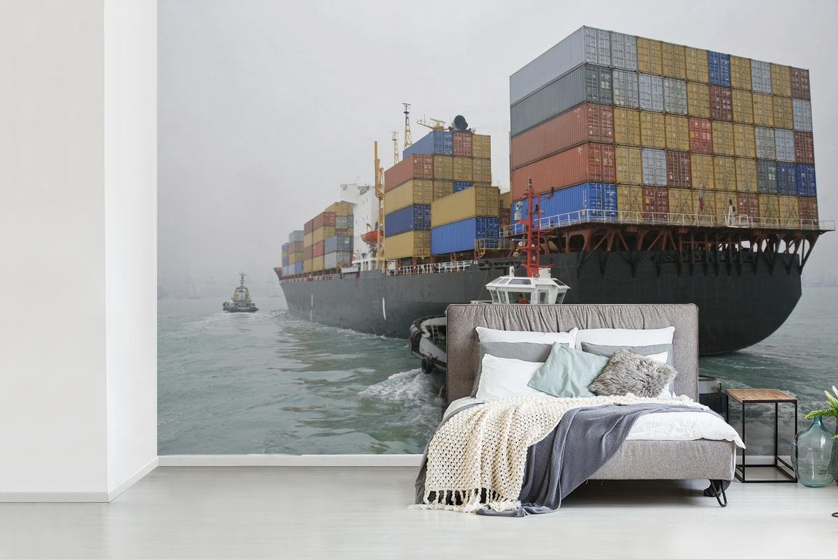 Behang - Fotobehang Sleepboot vaart naast een containerschip - Breedte 450 cm x hoogte 300 cm