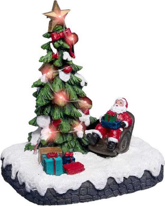 Kerstdorp, kersttafereel met de Kerstman onder de kerstboom