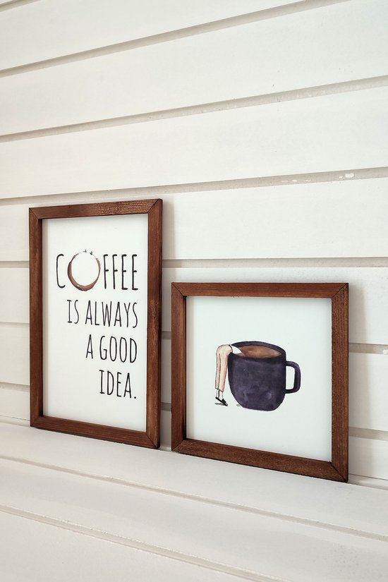 Twee houten lijsten met koffiethema. Links: 'COFFEE IS ALWAYS A GOOD IDEA.' Rechts: man met benen omhoog in een grote mok koffie.