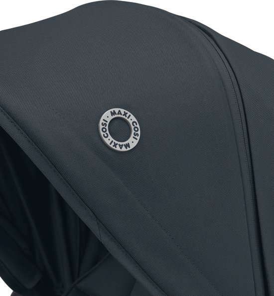 Close-up van het donkerblauwe Maxi-Cosi logo op de kap van de kinderwagen.