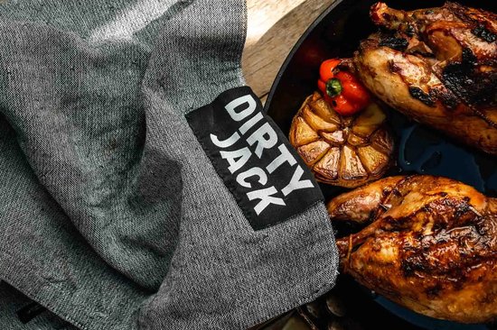Grijze keukendoek met zwart label 'DIRTY JACK' naast twee gegrilde kippen.