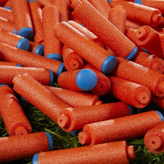 Een hoop oranje Nerf pijltjes met blauwe doppen, verspreid op groen gras.