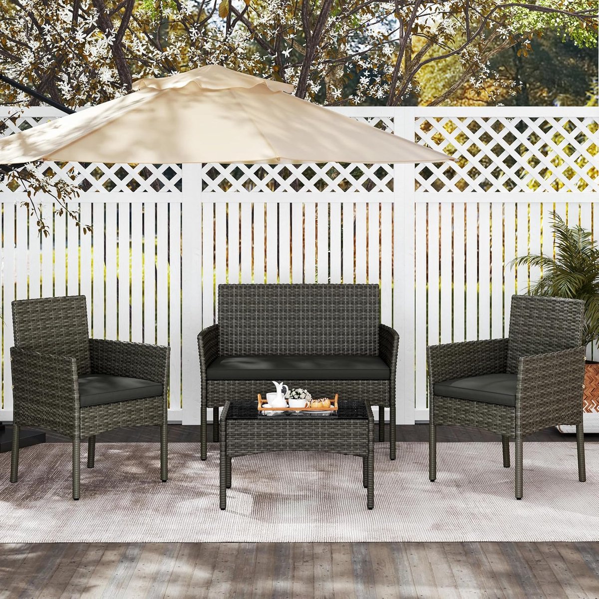 4-delige grijze polyrotan tuinmeubelset met 2-zitsbank, 2 stoelen en tafel.