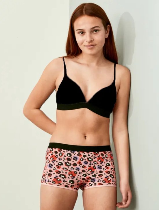 Meisje met zwarte beugel bh en luipaardprint shorts.