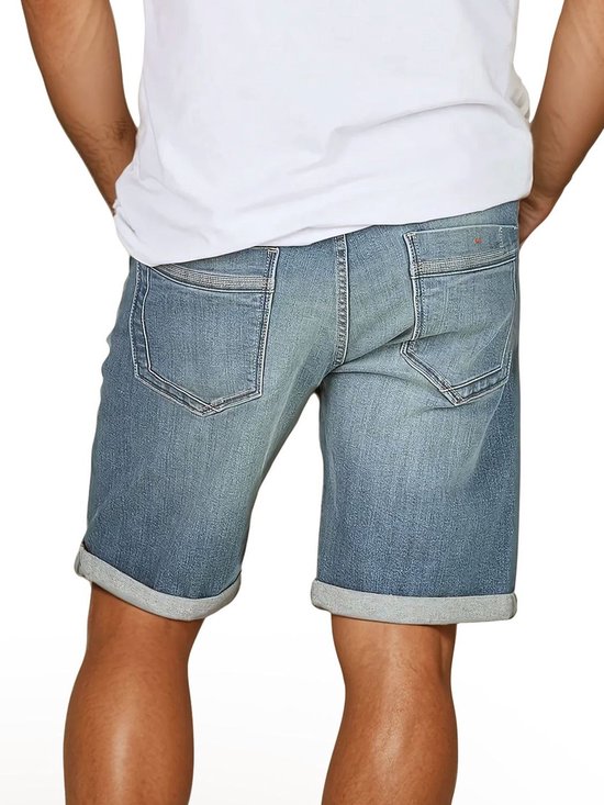 Achterkant, man draagt blauwe denim short met omgeslagen broekspijpen en zakdetails.