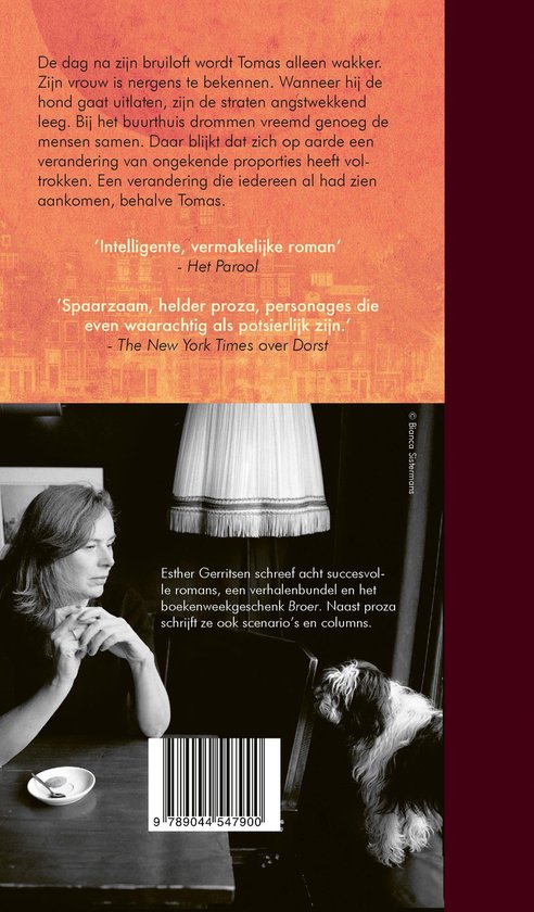 Een vrouw met bruin haar, gekleed in een zwart vest, zit aan een tafel met een hond op de achtergrond. Boekkaft met tekst.