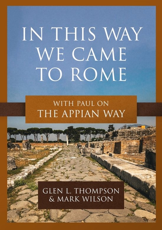 Boekomslag met de titel 'IN THIS WAY WE CAME TO ROME' en 'WITH PAUL ON THE APPIAN WAY'. Onder de titel staat een foto van de antieke Romeinse Via Appia.