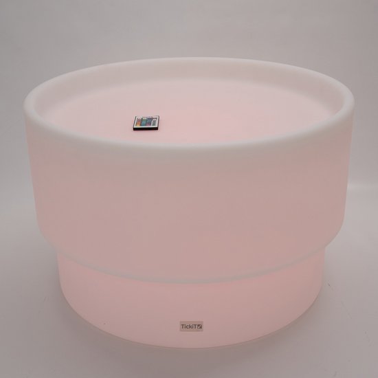 Une table de jeu vide éclairée en rose avec une télécommande sur la surface.