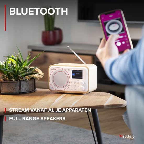 Retro radio met witte voorkant en houten zijkanten, aangesloten op smartphone.