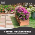 Houten plantenbak gevuld met roze en rode bloemen op een terras met stonede tegels.