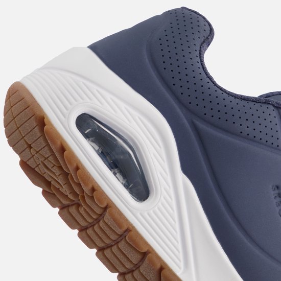 Close-up van de witte zool en blauwe bovenkant van een Skechers sneaker met luchtdemping.