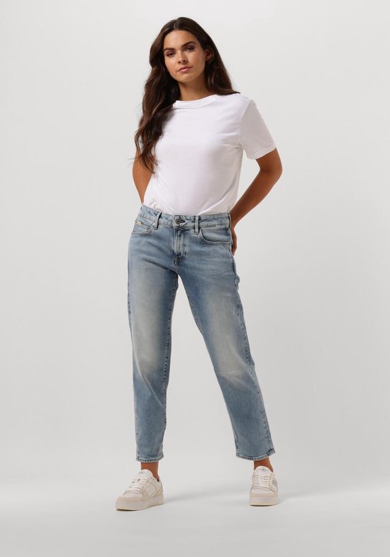 Model in een lichtblauwe G-Star jeans met witte sneakers.