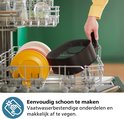 Een hand plaatst de mand van de zwarte Philips Airfryer in een vaatwasser.