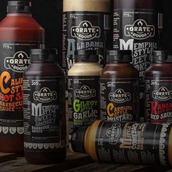 Groep flessen Grate Goods barbecue sauzen waaronder California Hot Sauce, Memphis Style Sweet & Smokey, Gilroy Garlic, Carolina Style Mustard, Kansas City Red Sauce.