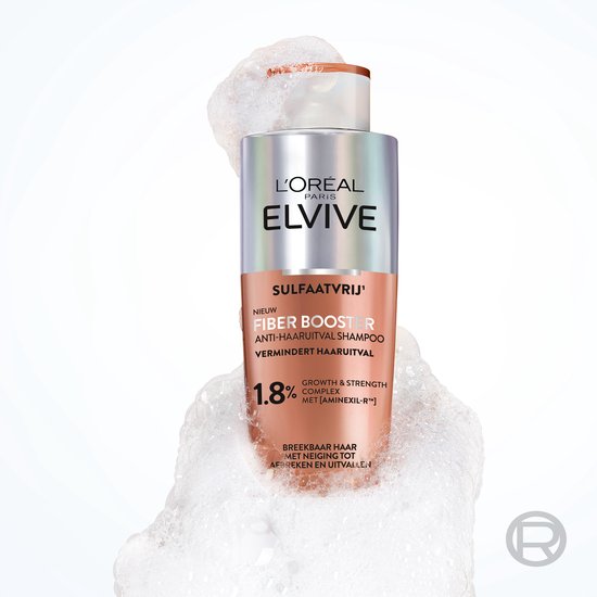 L'Oréal Elvive Fiber Booster shampoo met 1.8% complex, in een koperkleurige fles, omgeven door schuim.