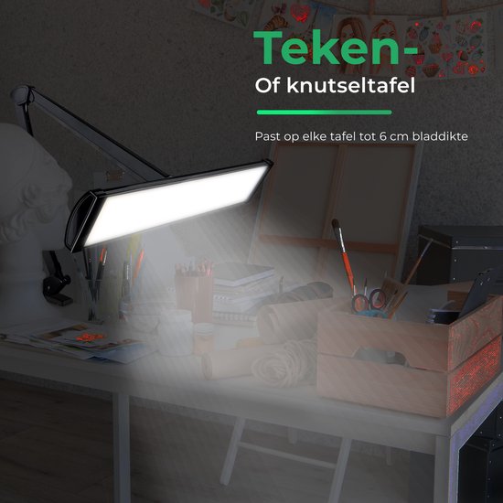 Zwarte bureaulamp met flexibele arm verlicht een creatieve werkplek.