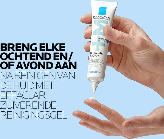 Une main presse de la crème hors du tube La Roche-Posay Effaclar Duo+M sur un doigt.