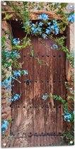 Tuinposter – Blauwe Bloemetjes Groeiend bij Houten Deur - 50x100 cm Foto op Tuinposter (wanddecoratie voor buiten en binnen)