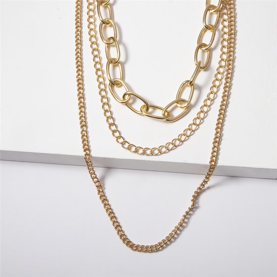 Goudkleurige schakelketting met fijne en grove schakels op een witte achtergrond.
