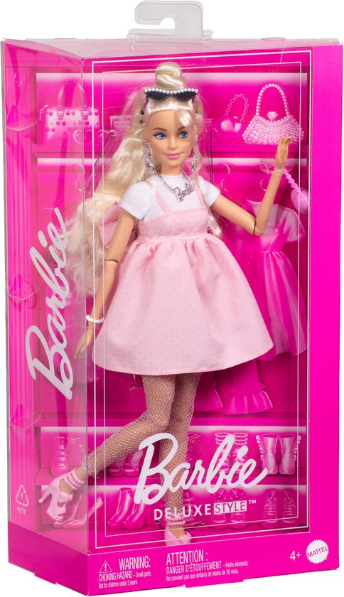 Barbiepop in pastelroze jurk met strik, visnetpanty's en hartvormige tas, in de verpakking.