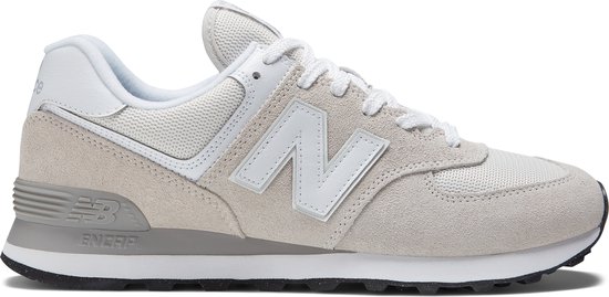 Lichtgrijze New Balance 574 sneaker met witte veters en witte 'N' op de zijkant.