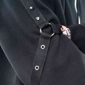 Detail van de mouw van een zwarte hoodie met een stoffen band, studs en een metalen ring.
