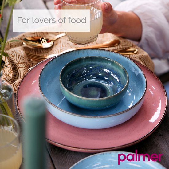 Roze en blauwe borden en kommen op een tafel met gouden bestek. 'For lovers of food' tekst.