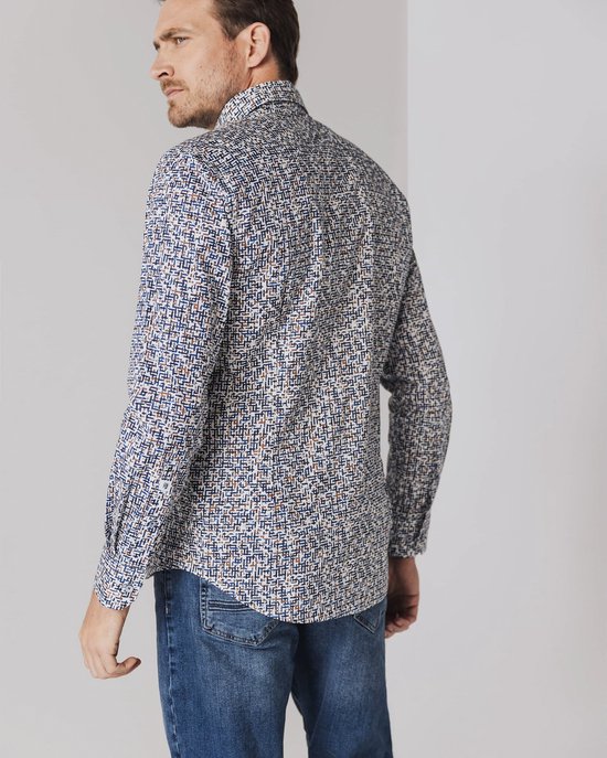 Man van achteren gezien, draagt een blauw overhemd met een print van witte, bruine en donkerblauwe lijntjes. Jeans erbij.