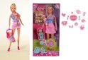 Steffi Love pop als babysitter met twee baby's. Ze draagt een roze jurk en houdt een baby in draagzak vast. Een wiegje met baby staat naast haar.