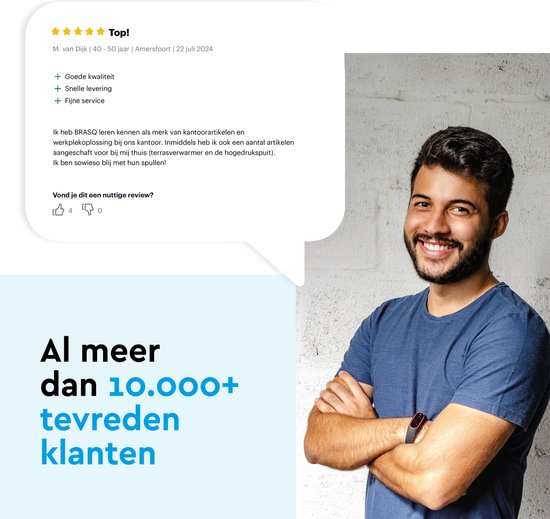 Een lachende man met gevouwen armen voor een witte bakstenen muur.