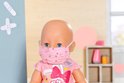 Close-up van een baby Born pop met een roze masker met hartjespatroon en een dokterstas-badge.