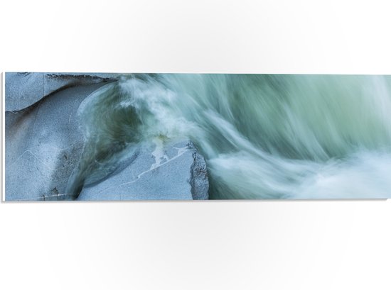 WallClassics - PVC Schuimplaat - Blauw Stromend Water langs Stenen - 60x20 cm Foto op PVC Schuimplaat (Met Ophangsysteem)