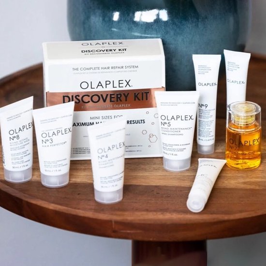 Olaplex Discovery Kit op een houten tafel. De set bevat 7 mini-producten en de No.7 Bonding Oil.