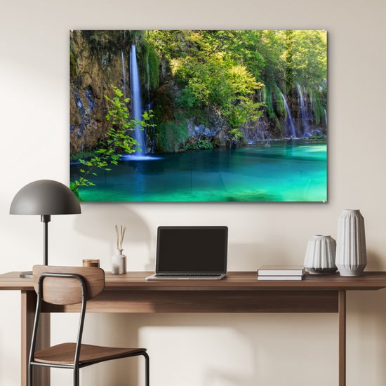 Acrylglas schilderij van de Plitvicemeren met waterval en turquoise water, op een bureau.